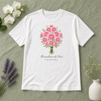 Camiseta Algodão Peruano Floricultura da Vovó branca, estendida em plano aberto, com o nome de 1 neto, personalizada com nomes dos netos