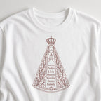 Camiseta Clássica Sob o Manto de Aparecida branca, em zoom no tecido, com 7 nomes de netos, personalizada com nomes dos netos