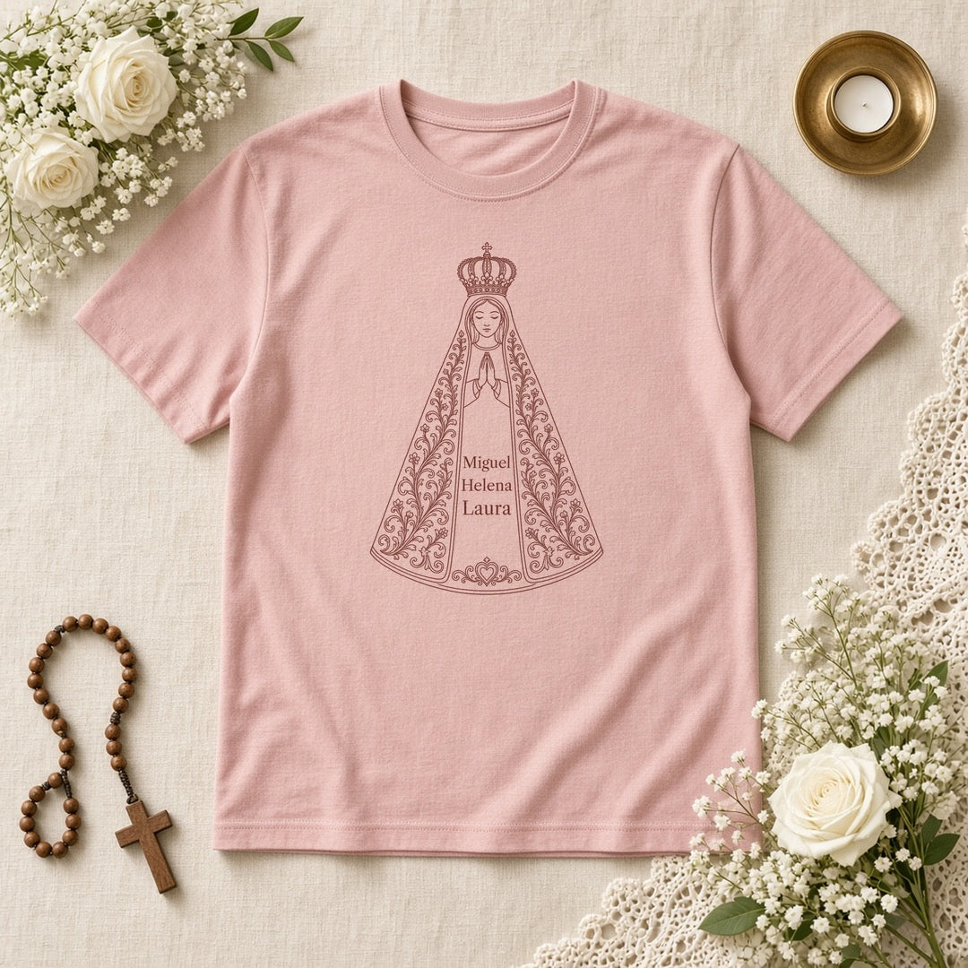 Camiseta Clássica Sob o Manto de Aparecida rosa, em plano aberto, com 3 nomes de netos, personalizada com nomes dos netos