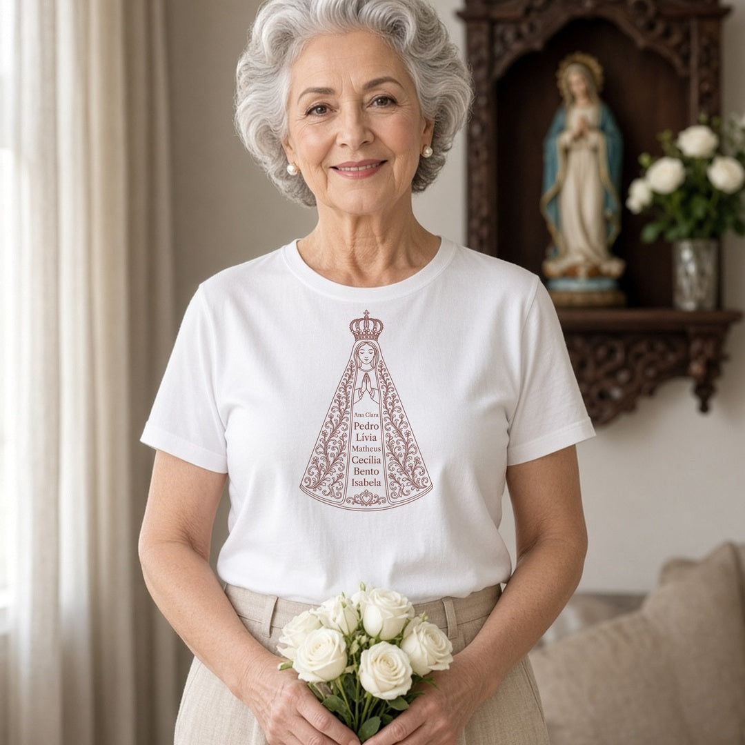 Camiseta Clássica Sob o Manto de Aparecida branca, vestida por vovó, com 7 nomes de netos, personalizada com nomes dos netos