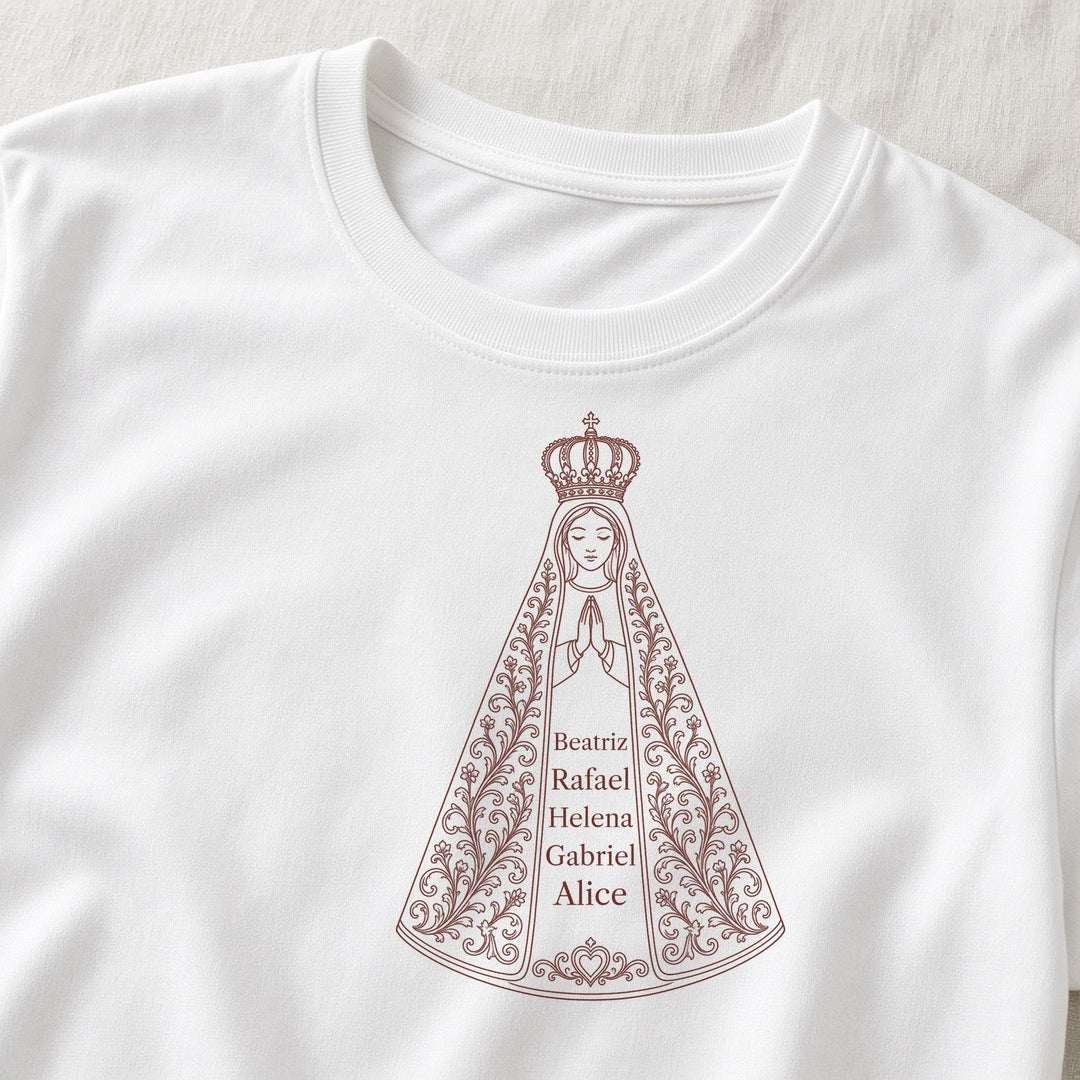 Camiseta Algodão Peruano Sob o Manto de Aparecida branca, em zoom no tecido, com 5 nomes de netos, personalizada com nomes dos netos