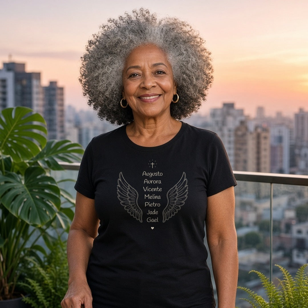 Avó de cabelo crespo grisalho em uma varanda com vista da cidade vestindo a camiseta Clássica Os Anjos da Vovó preta com asas de anjo e os nomes de 7 netos