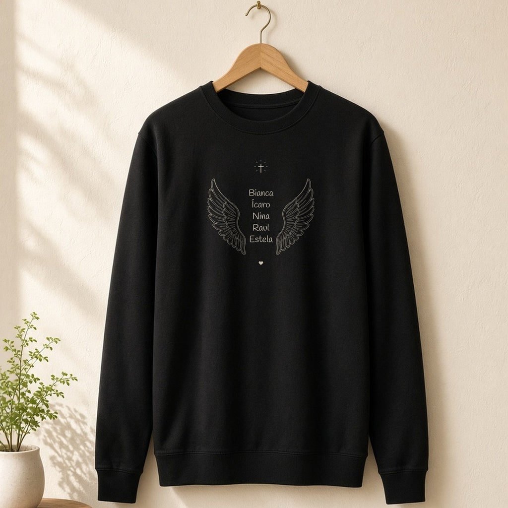 Suéter Os Anjos da Vovó preto pendurado em um cabide de madeira, com asas de anjo e os nomes de 5 netos, personalizado com os nomes dos netos