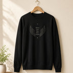 Suéter Os Anjos da Vovó preto pendurado em um cabide de madeira, com asas de anjo e os nomes de 5 netos, personalizado com os nomes dos netos